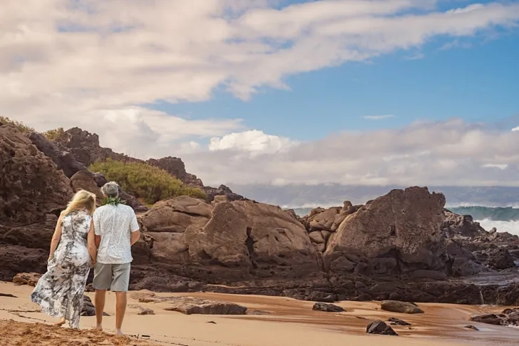 bride and groom looking at the shoreline on Hawaii beach