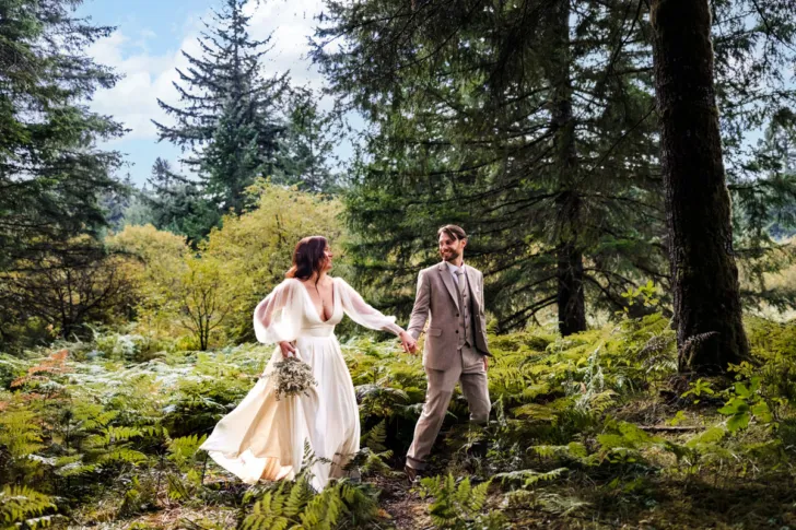 bride and groom holding hands in Oregon forest