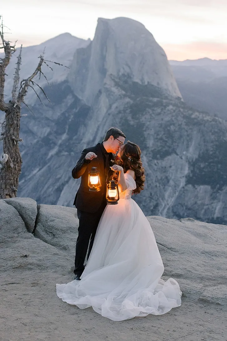 bride and groom kissing while holding lanterns