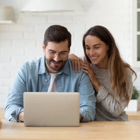 couple looking at computer at kitchen counter