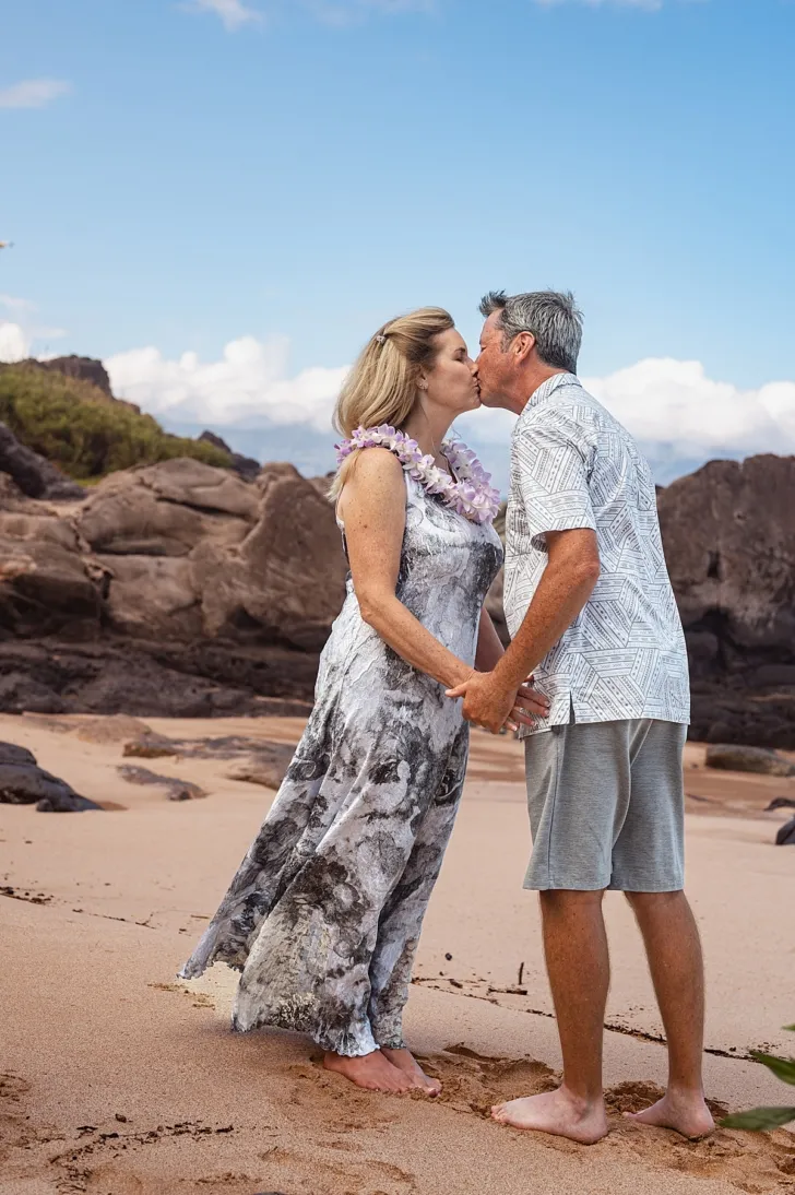 bride and groom kissing during wedding ceremony on beach
