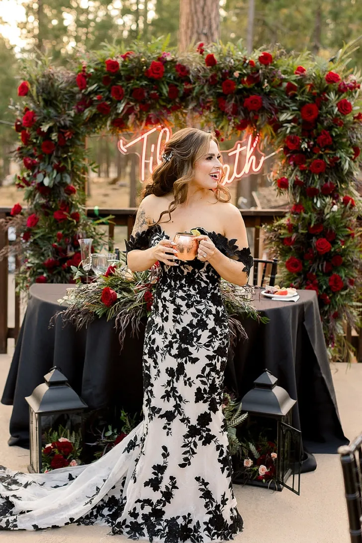 bride in white and black dress making a toast
