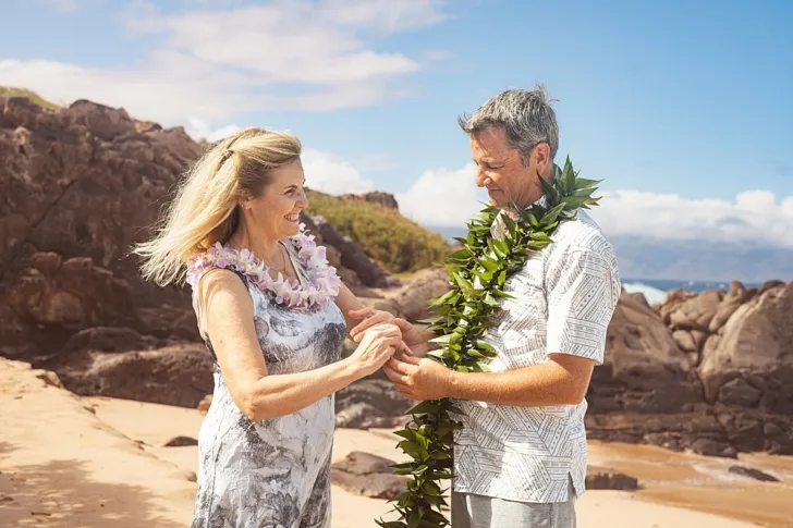 bride and groom exchanging rings during wedding ceremony on beach