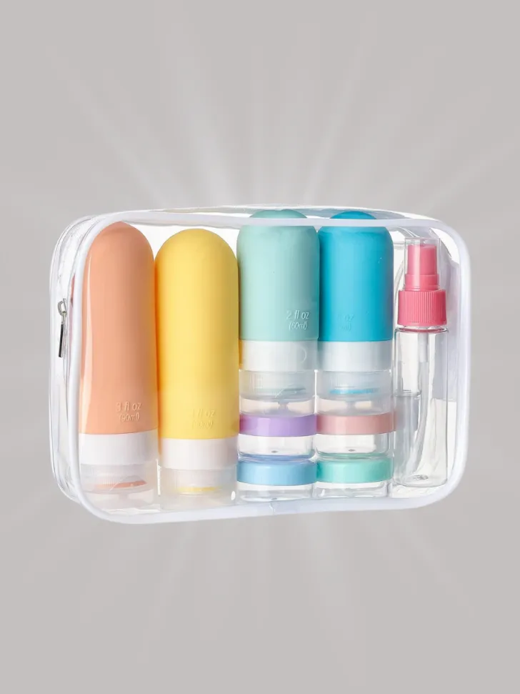 Clear travel toiletry bag containing multicolored silicone bottles, jars, and a spray bottle for liquids.