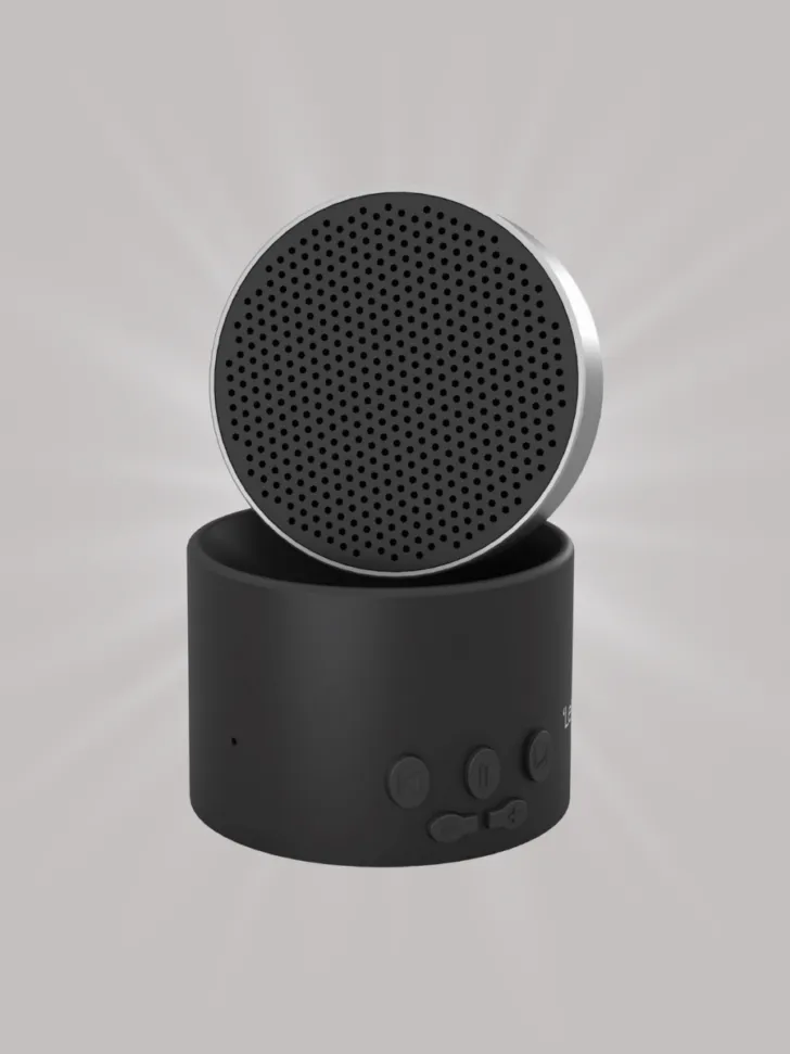 A compact, black portable Bluetooth speaker with a circular design, featuring simple control buttons at the base.