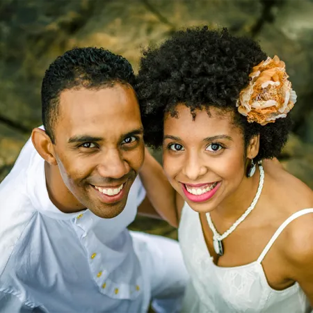 Photo of a Man and Woman Smiling While Standing on Rocks