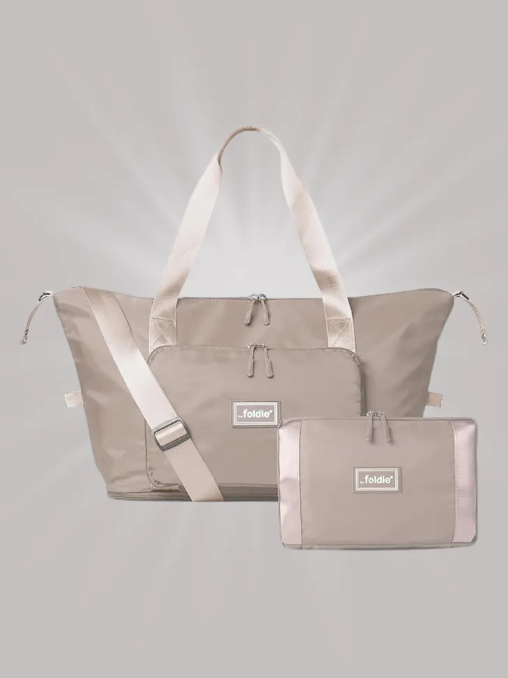 Beige foldable travel tote bag that collapses into a compact pouch.