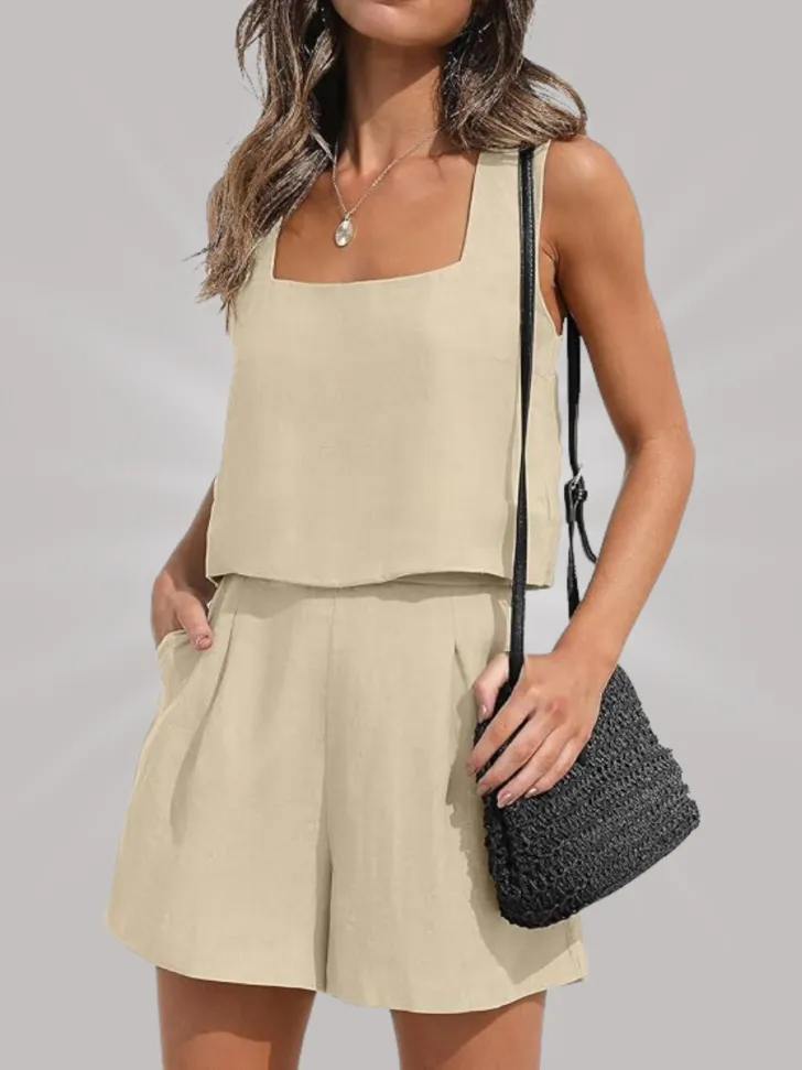 Beige two-piece outfit with a square neckline and pleated shorts, paired with a black woven crossbody bag.