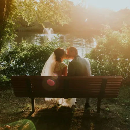 happy married wedding couple on a park bench